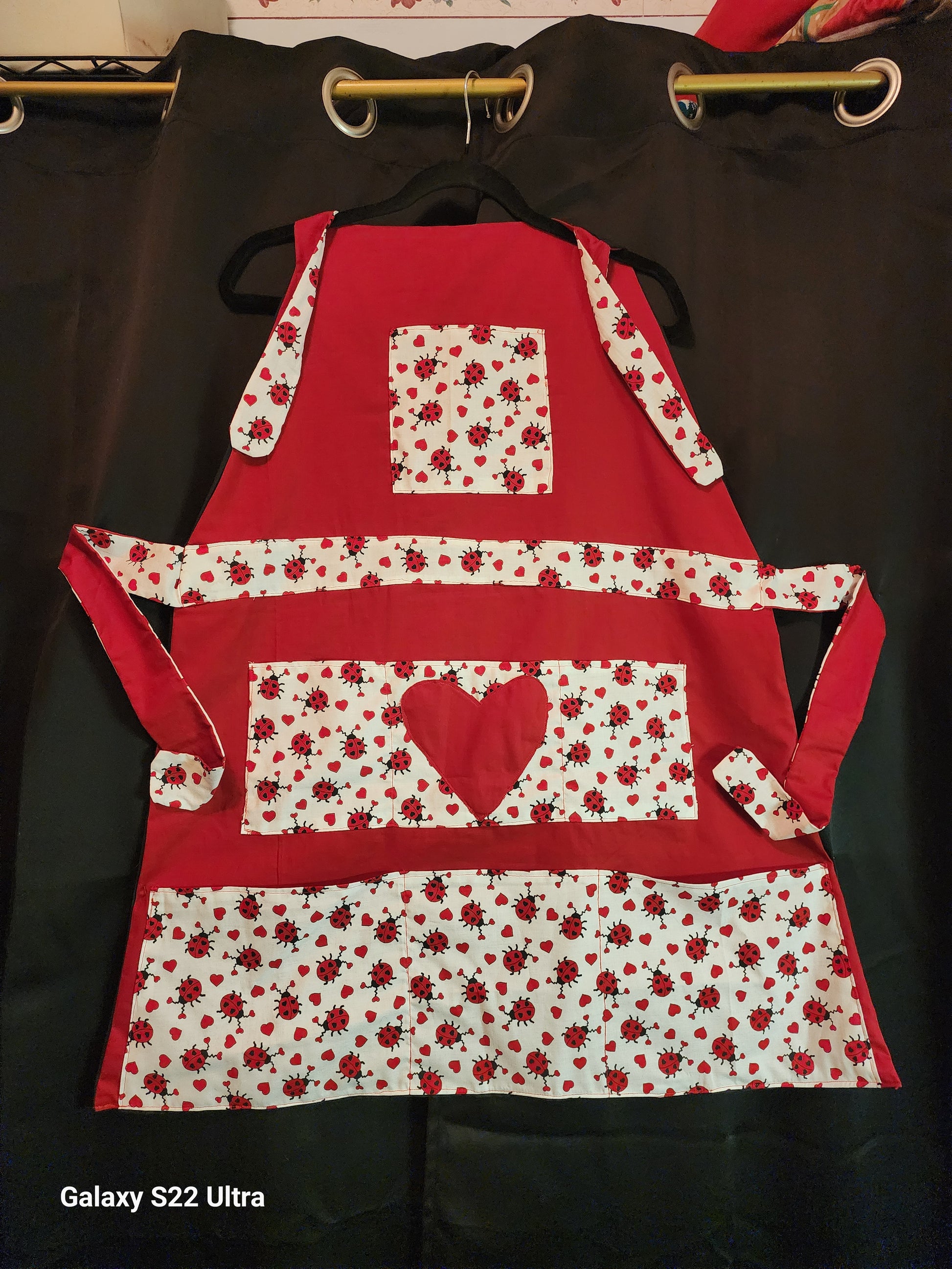 Celebrate love in the kitchen with our charming Love Bug adult apron! Handmade with care, this apron features a rich red base accented by an adorable ladybug-and-heart print that brings playful Valentine vibes to any bake day or dinner prep.