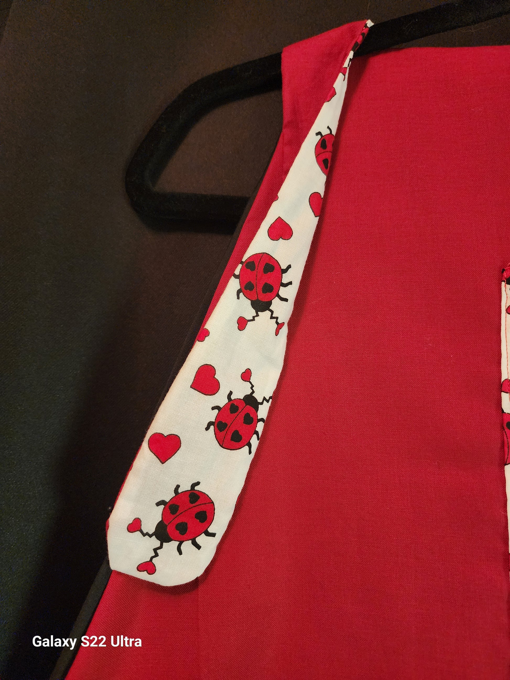 Celebrate love in the kitchen with our charming Love Bug adult apron! Handmade with care, this apron features a rich red base accented by an adorable ladybug-and-heart print that brings playful Valentine vibes to any bake day or dinner prep.