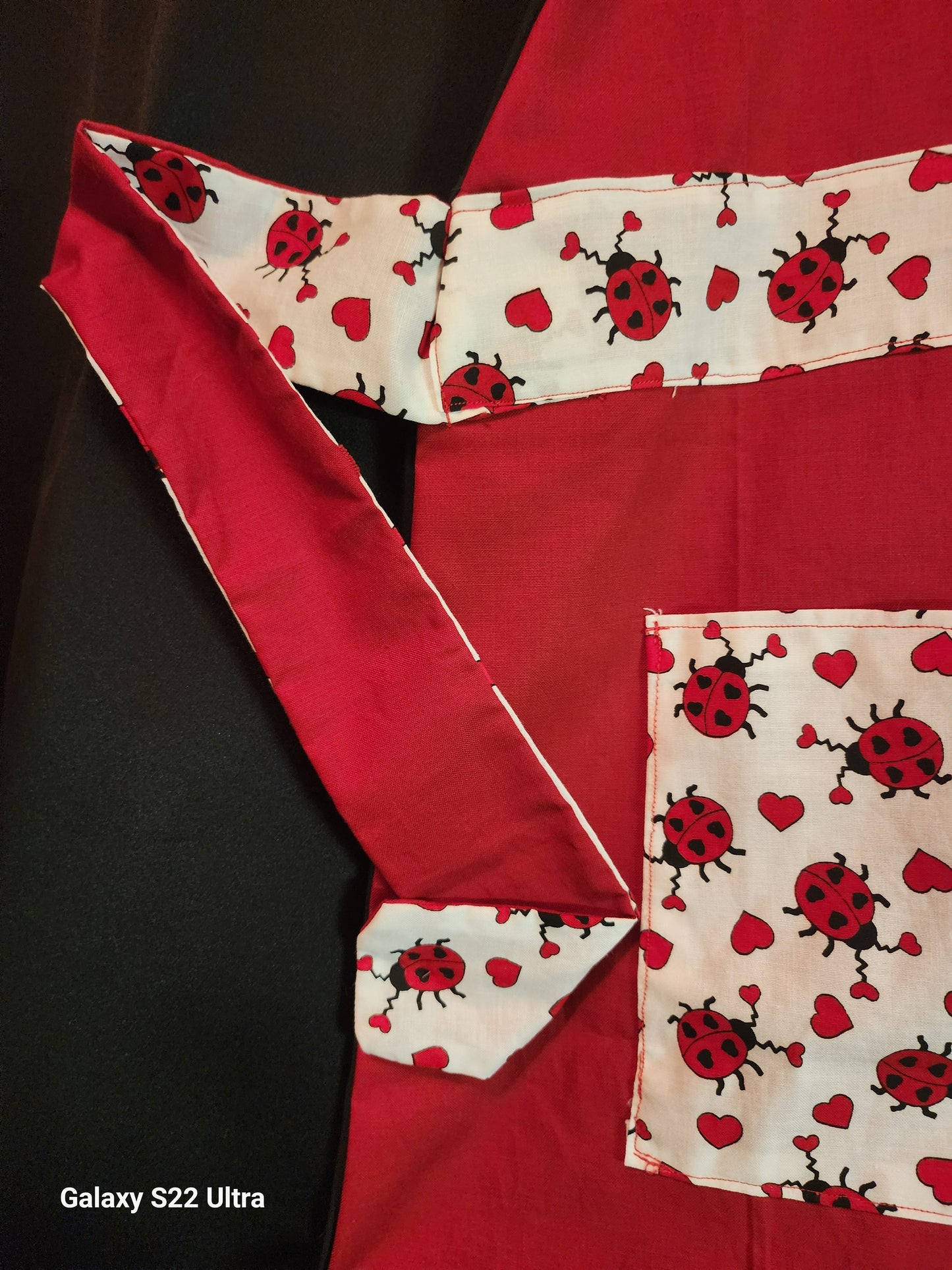 Celebrate love in the kitchen with our charming Love Bug adult apron! Handmade with care, this apron features a rich red base accented by an adorable ladybug-and-heart print that brings playful Valentine vibes to any bake day or dinner prep.
