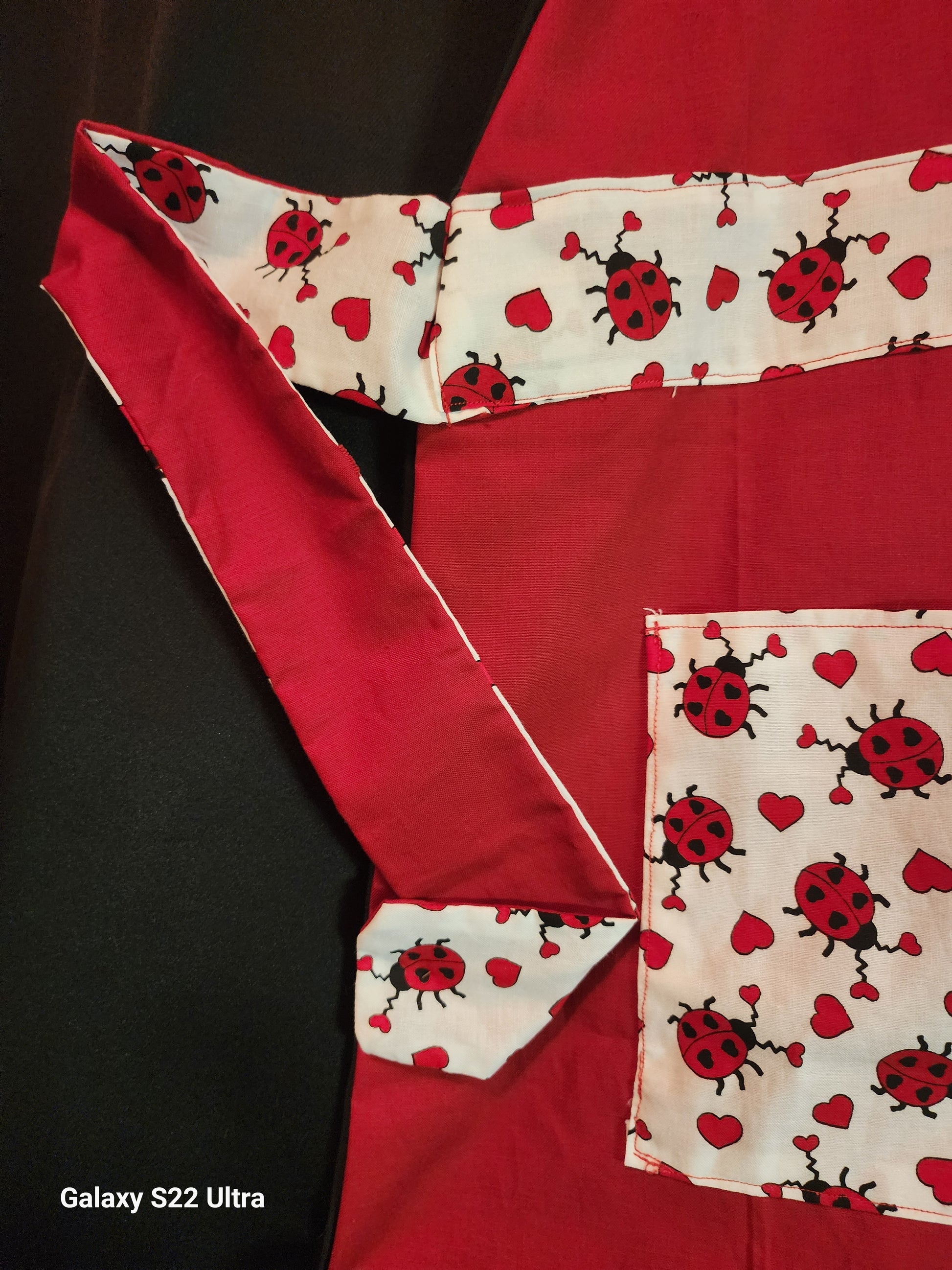 Celebrate love in the kitchen with our charming Love Bug adult apron! Handmade with care, this apron features a rich red base accented by an adorable ladybug-and-heart print that brings playful Valentine vibes to any bake day or dinner prep.