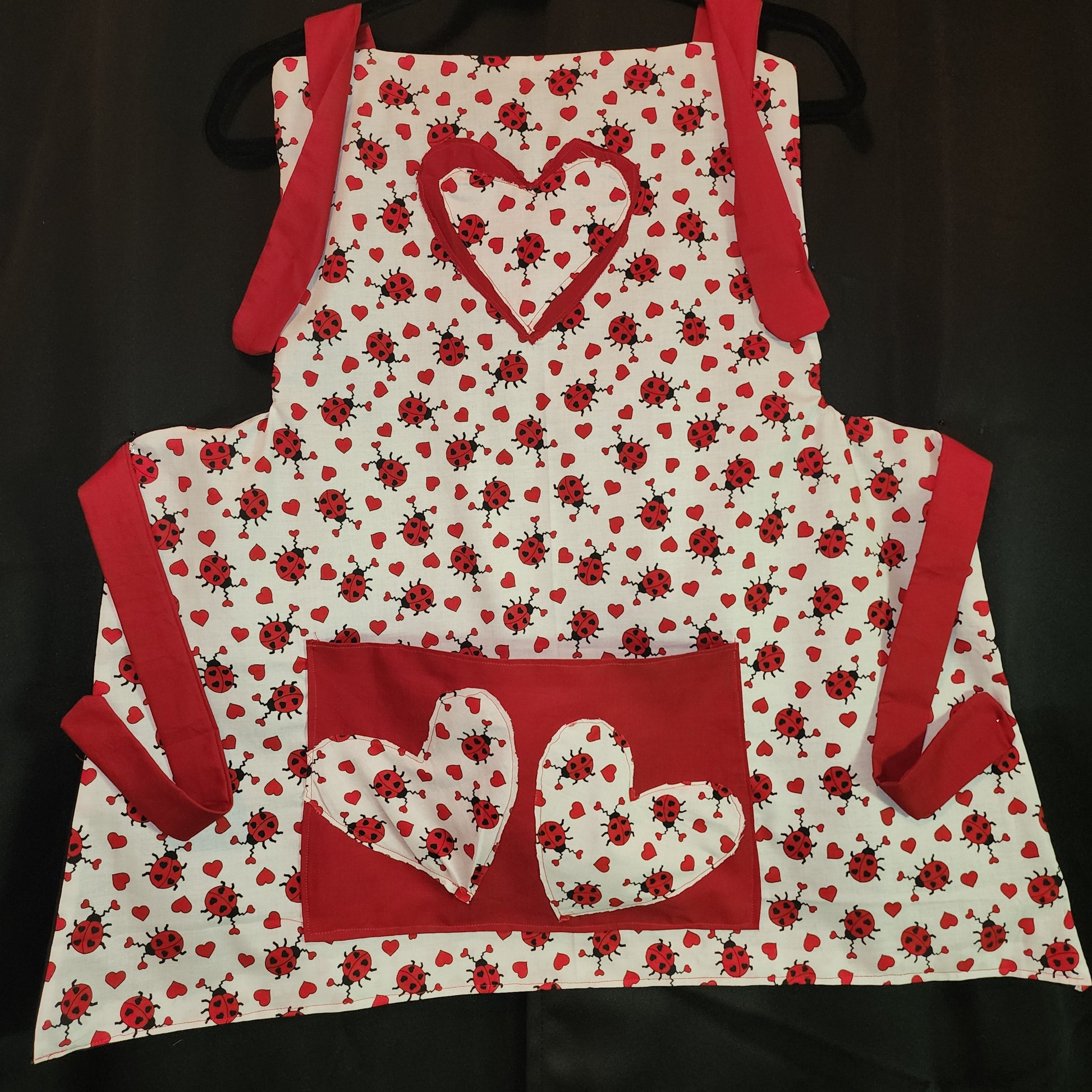 Make Valentine’s Day extra sweet with our&nbsp;Love Bug Child Apron, thoughtfully handmade to match our coordinating adult apron for the perfect parent-and-child kitchen duo. Featuring an all-over ladybug and heart print with charming red accents, this apron is designed to bring fun, love, and creativity into every little helper’s cooking or crafting adventure.